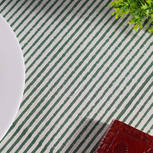 Green and white striped placemat with a plant and plate on a table