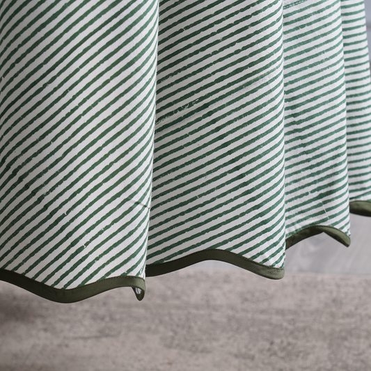 Green and white striped fabric with a textured pattern on a neutral background
