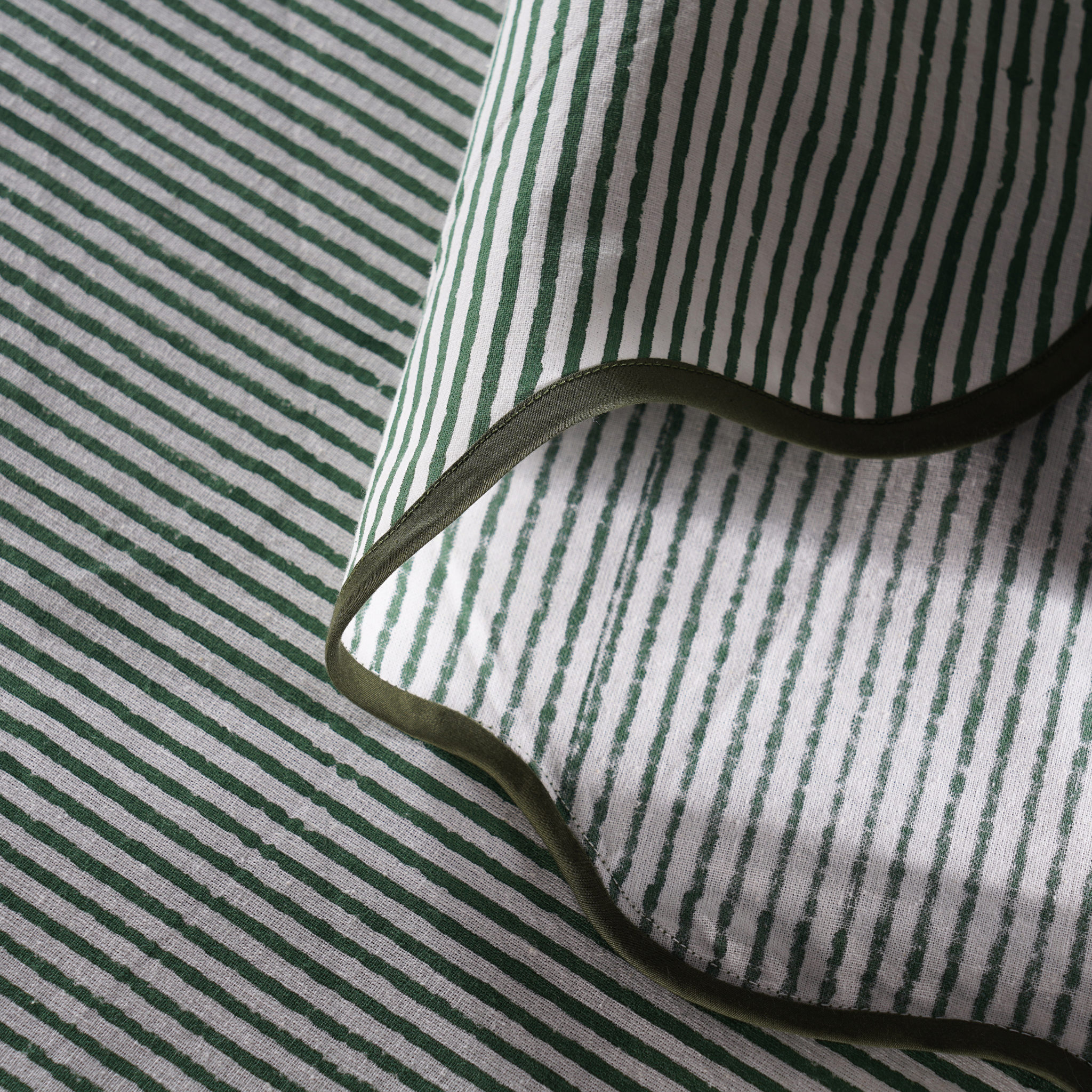 Close-up of green and white striped fabric with a black cord.