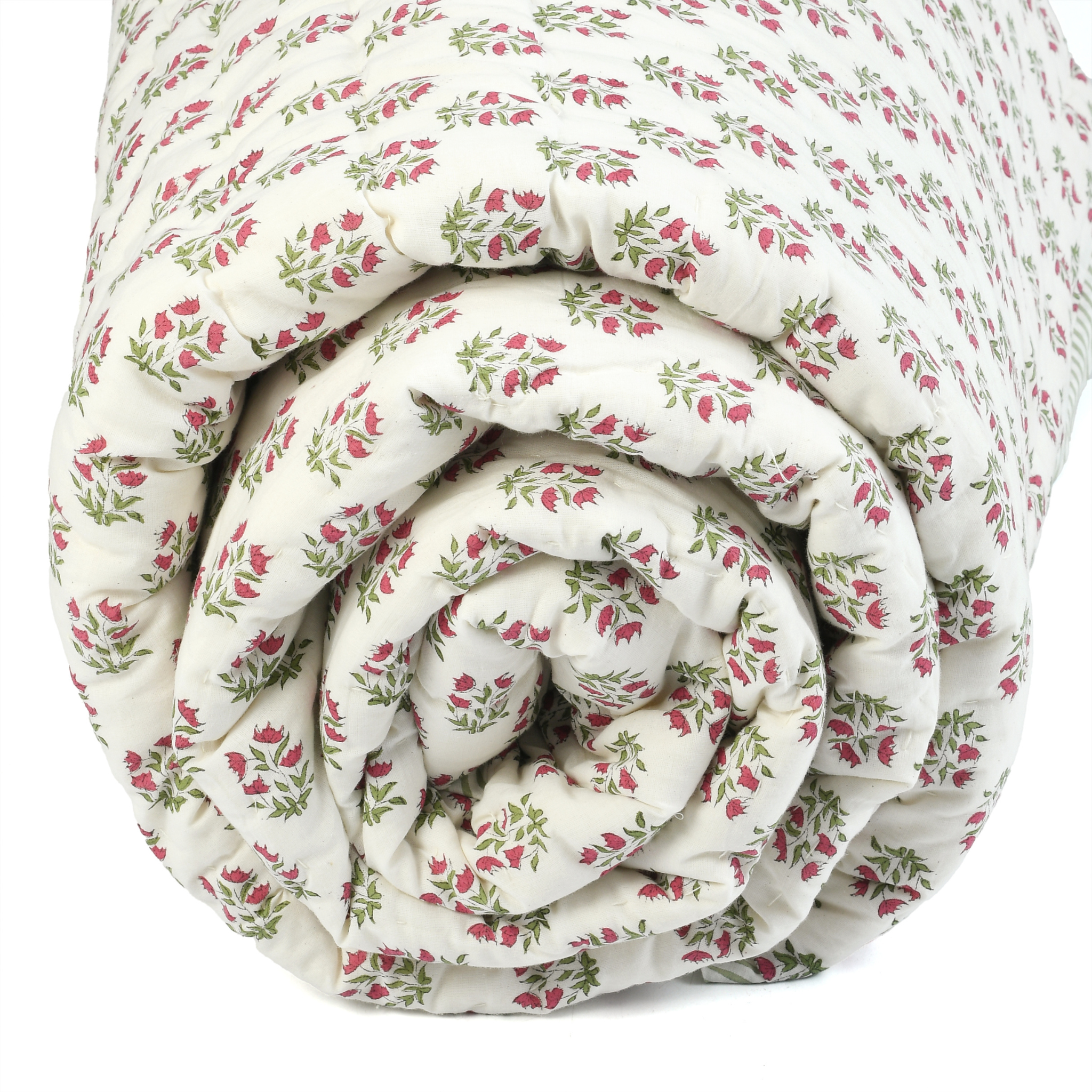 Rolled-up floral-patterned quilt on a white background