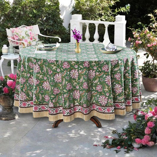 Outdoor table setting with a floral-patterned tablecloth, chairs, and decorative elements.