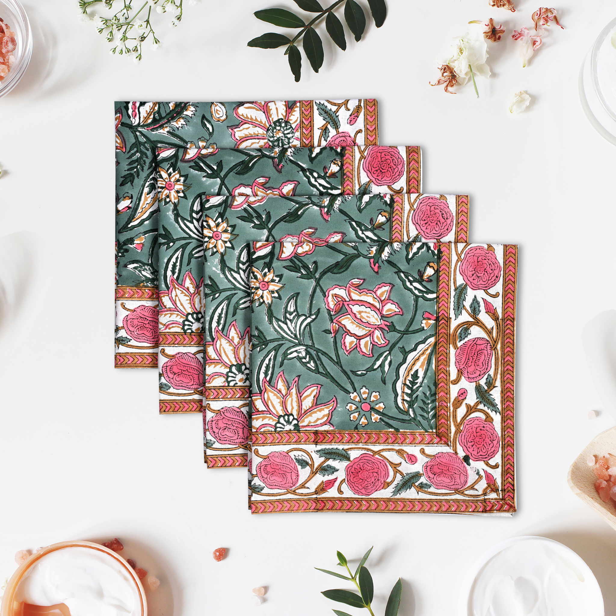 Set of floral patterned napkins on a white surface with decorative elements.