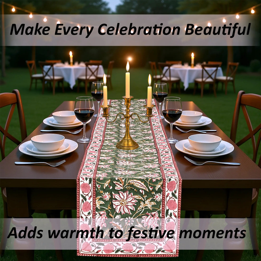 Dining table set for a celebration with a floral table runner, candles, and wine glasses outdoors.