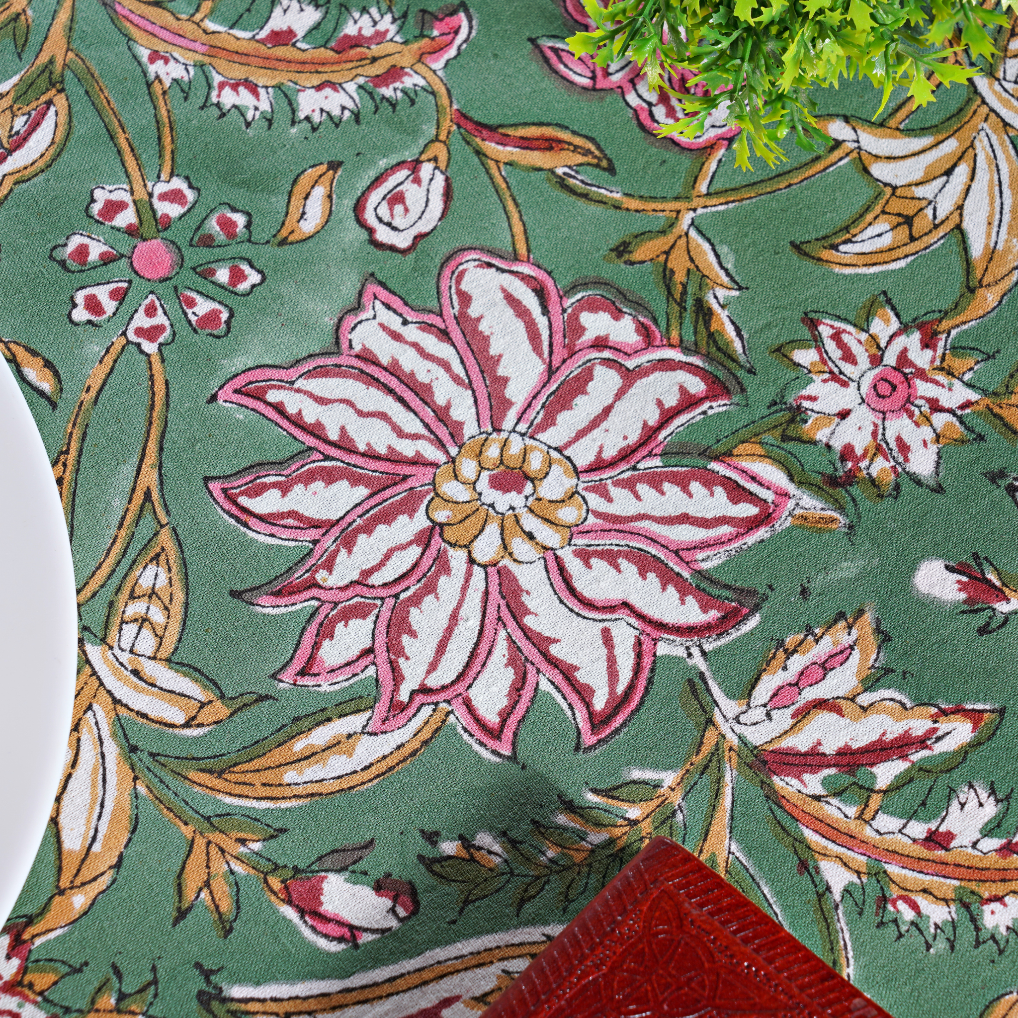 Floral patterned fabric with pink flowers on a green background