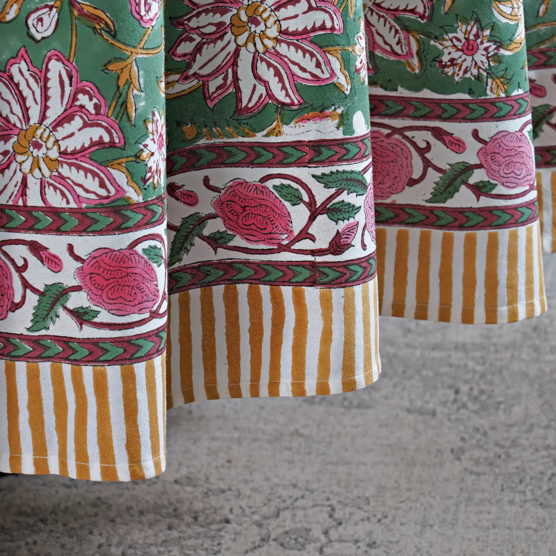 Close-up of colorful fabric with floral and striped patterns on a textured surface.
