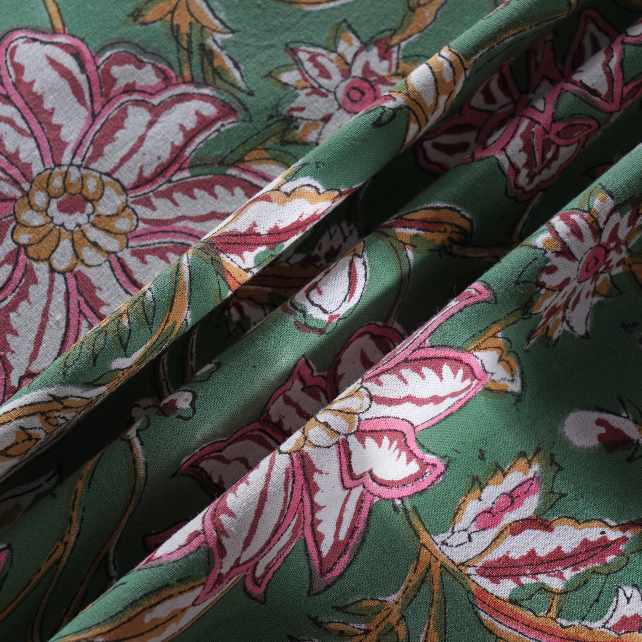 Close-up of floral fabric with pink and white flowers on a green background