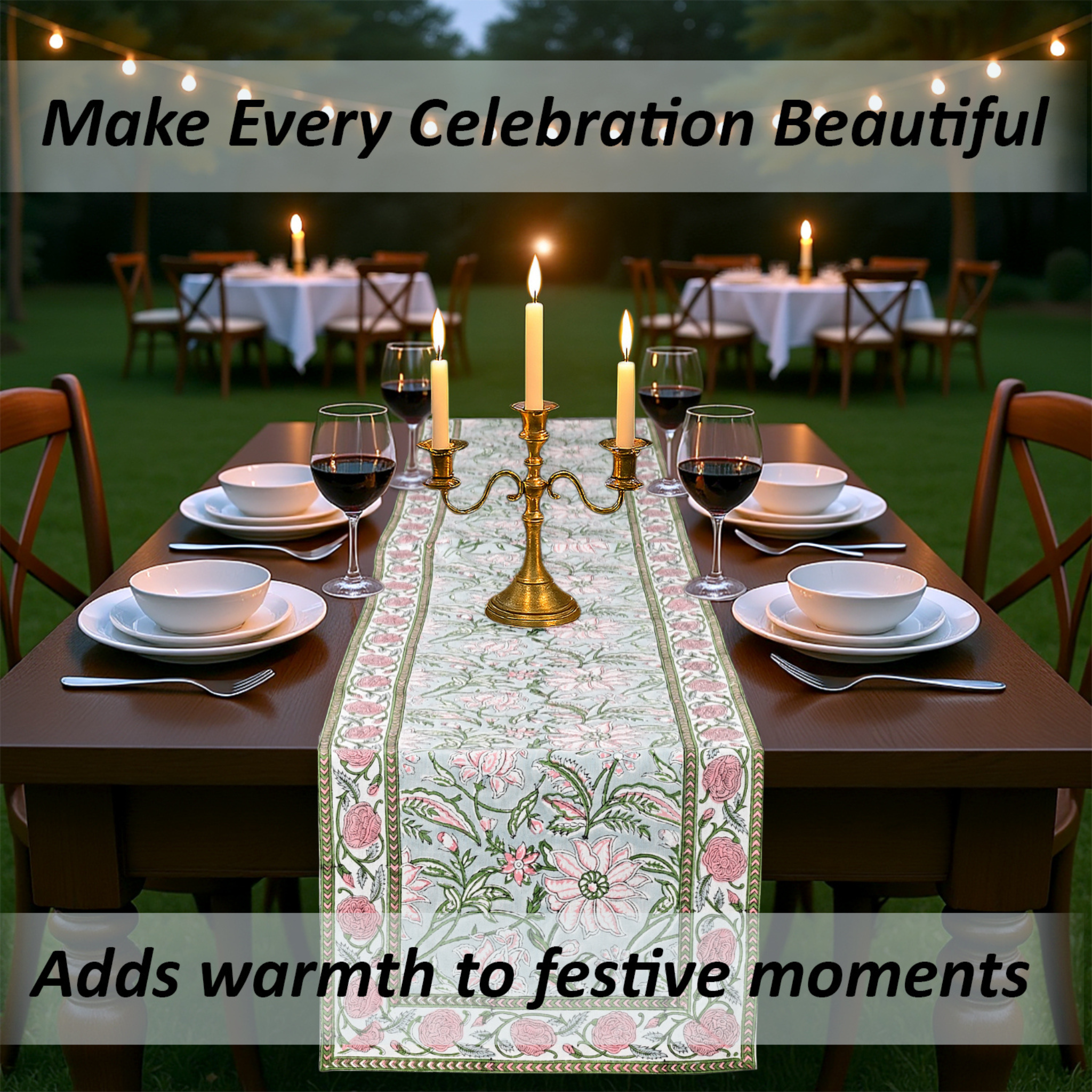 Dining table set with floral table runner, candles, and wine glasses outdoors.