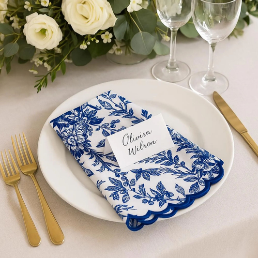Table setting with blue and white floral napkin, name card, and cutlery.