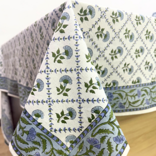 Three patterned tablecloths with floral and geometric designs on a wooden surface.