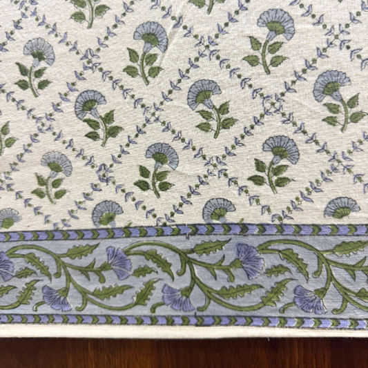 Floral patterned fabric with blue and green flowers on a beige background