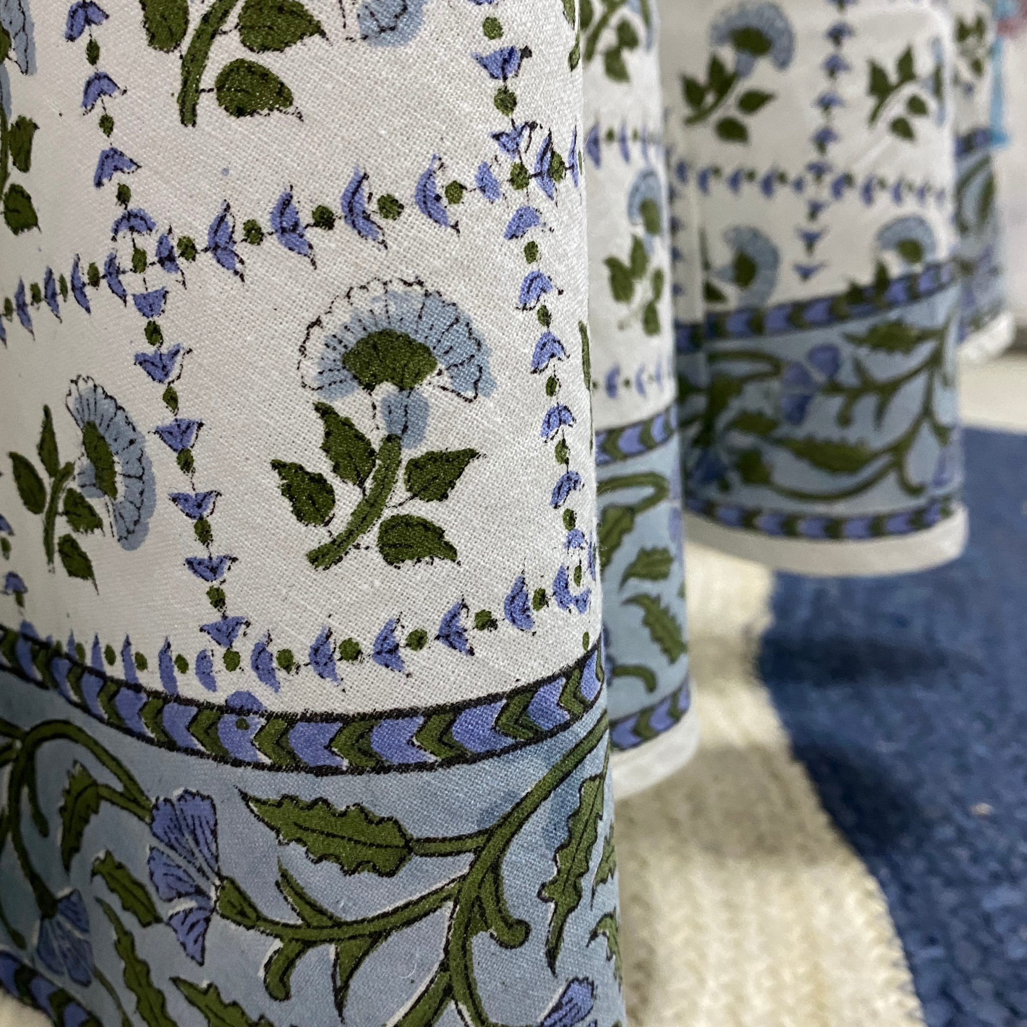 Close-up of a fabric with floral patterns in blue and green on a white background.