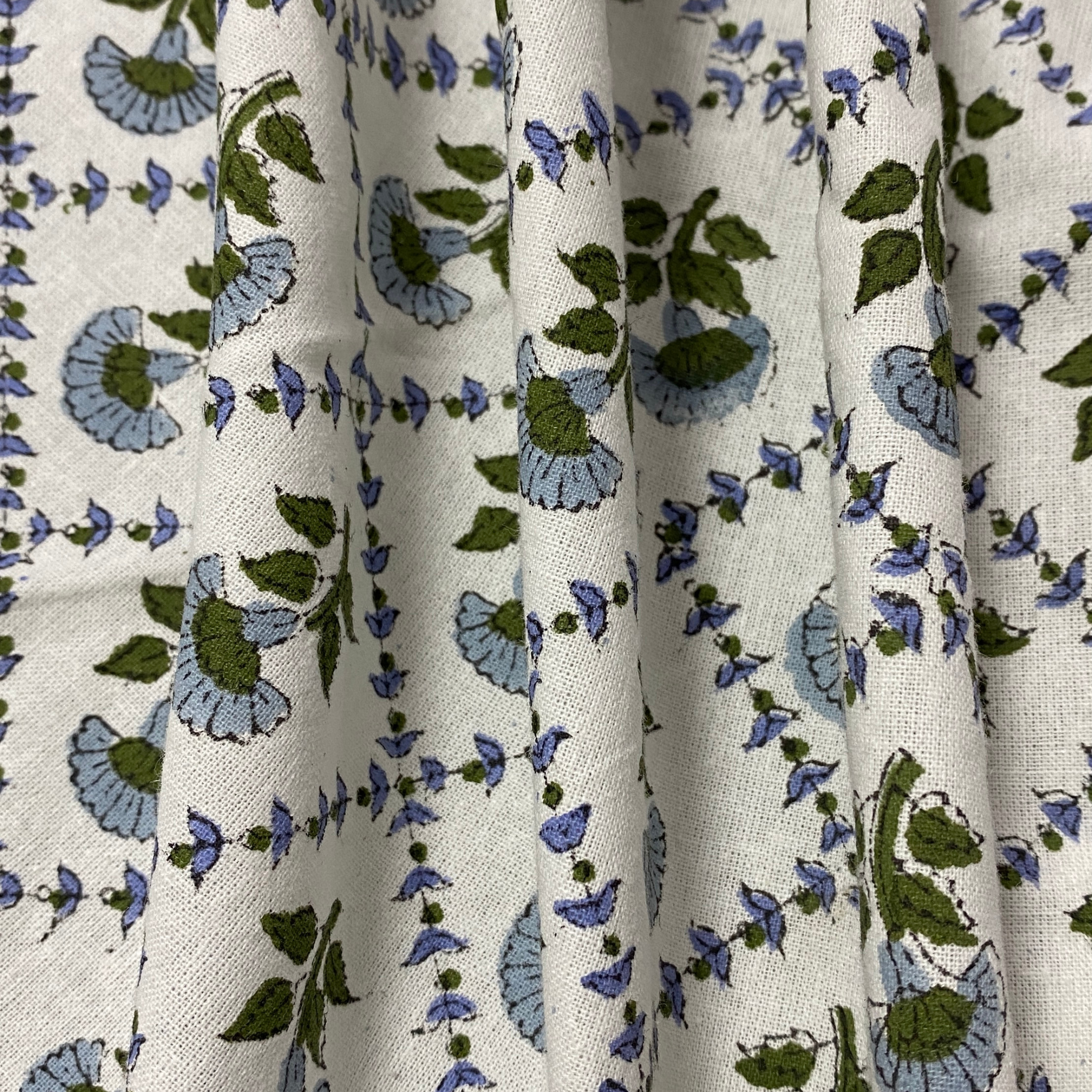 Floral patterned fabric with blue and green flowers on a white background