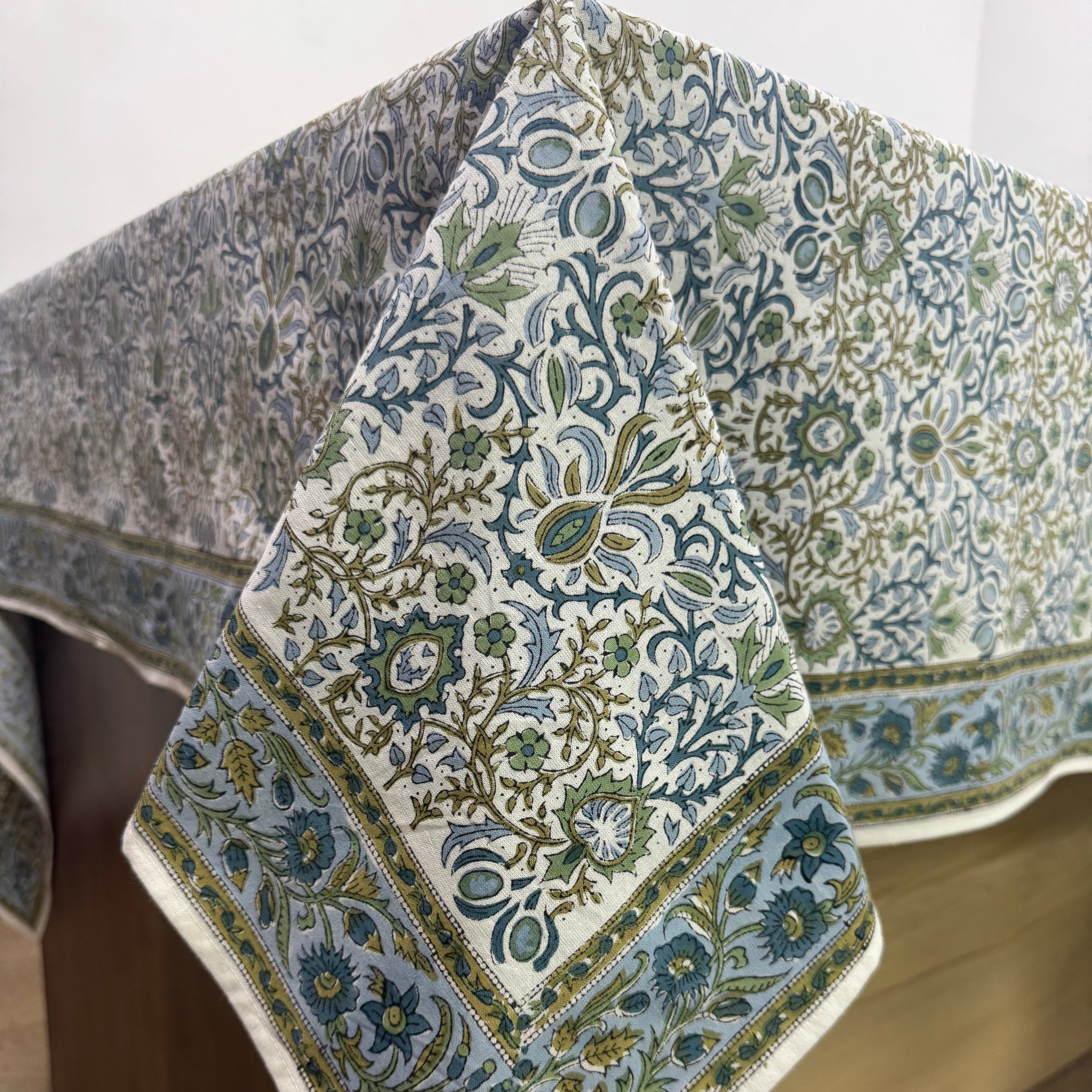 Decorative tablecloth with intricate floral pattern on a wooden surface