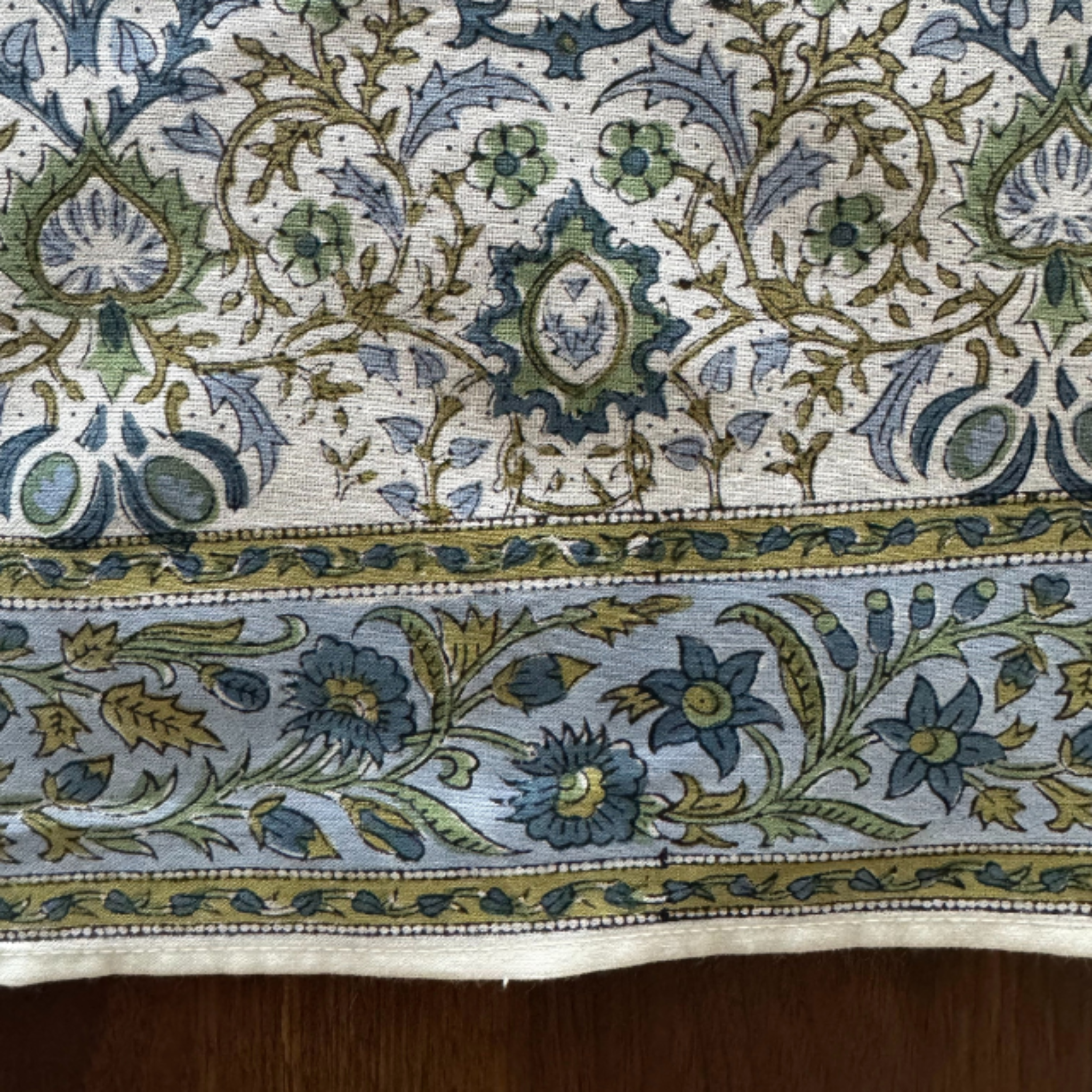 Close-up of a patterned fabric with blue, green, and beige colors.