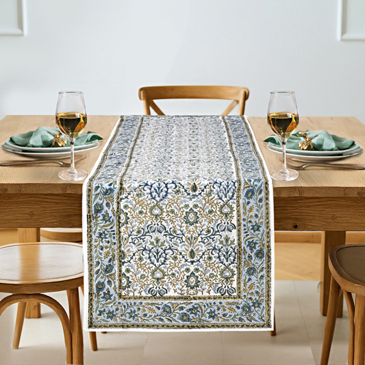 Dining table set with a decorative table runner, glasses, and plates.