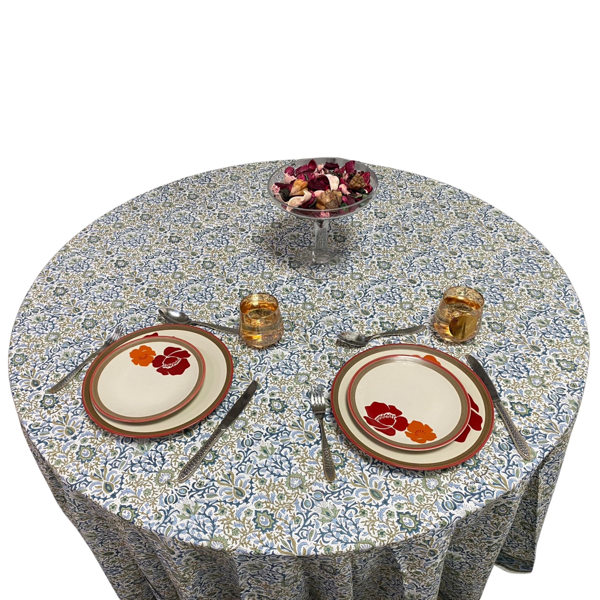 Round table with floral tablecloth, plates, and glasses on a white background