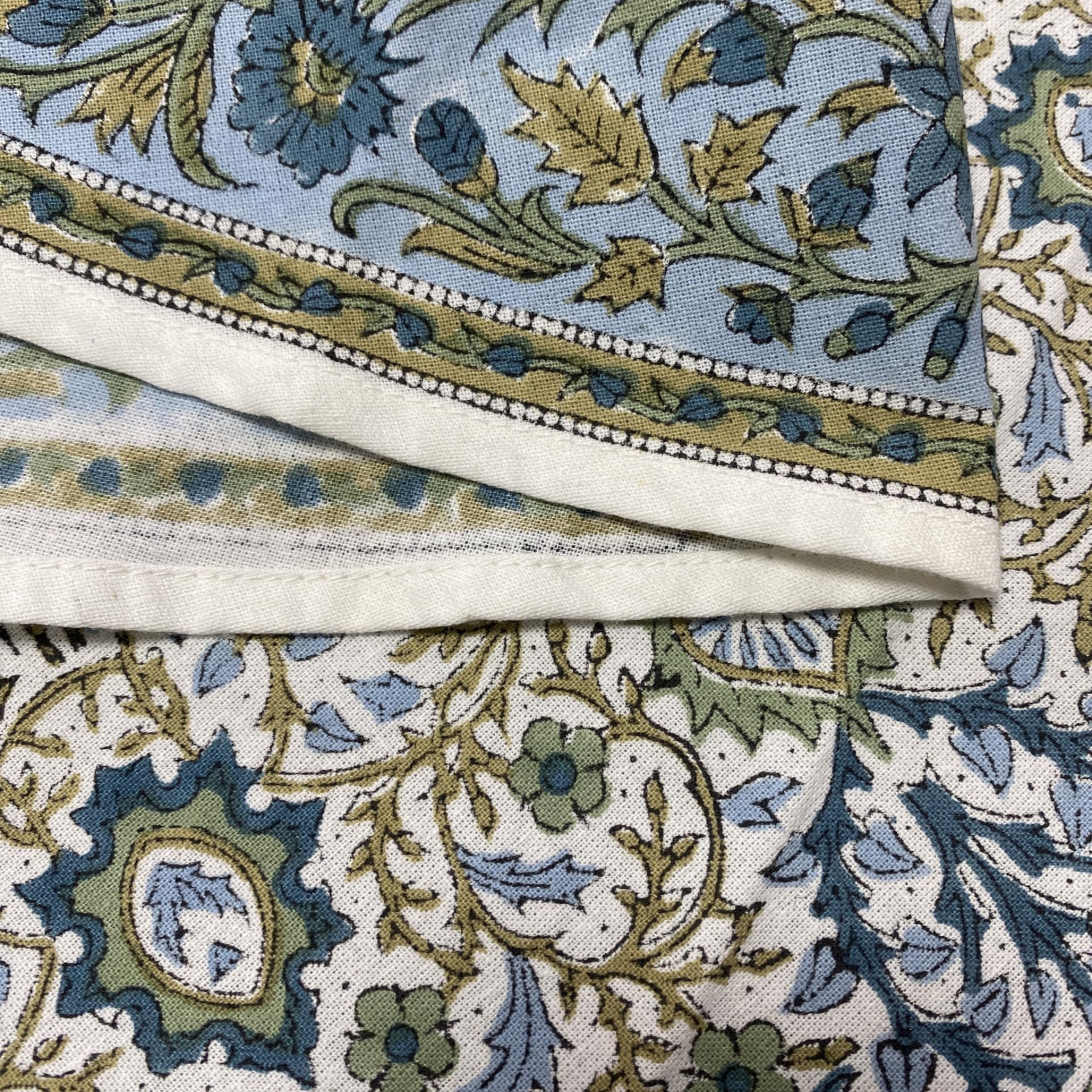 Close-up of patterned fabric with blue, green, and beige colors.