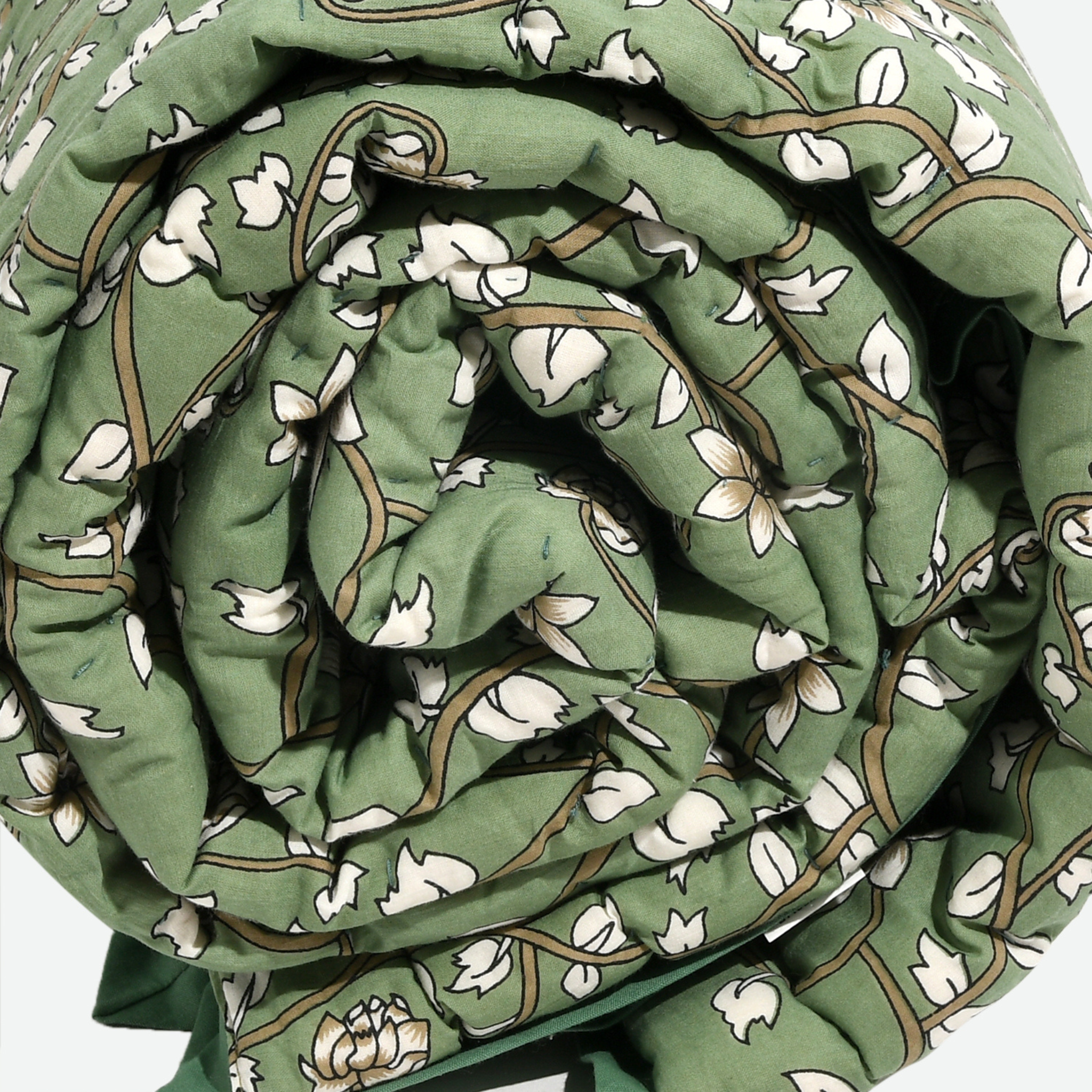 Rolled-up green fabric with white floral pattern on a white background
