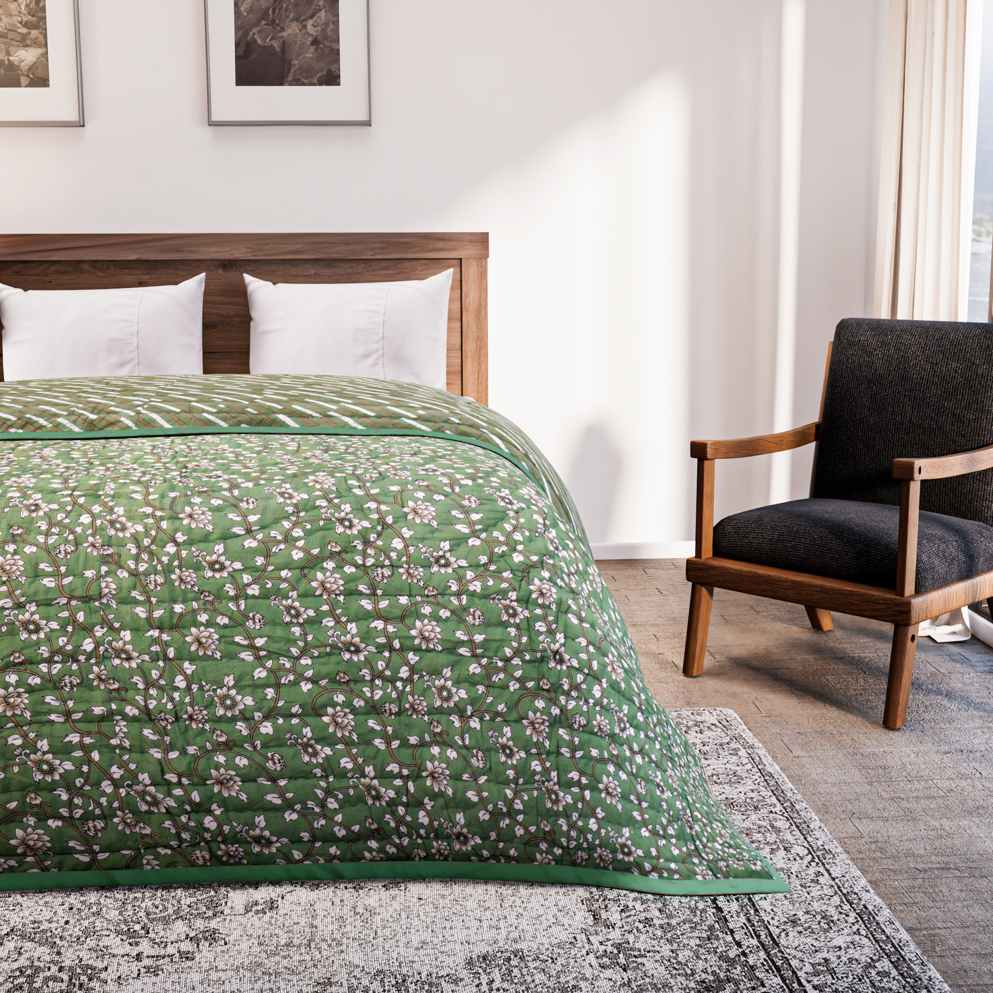 Bed with green floral quilt in a bedroom setting with a chair and artwork on the wall.