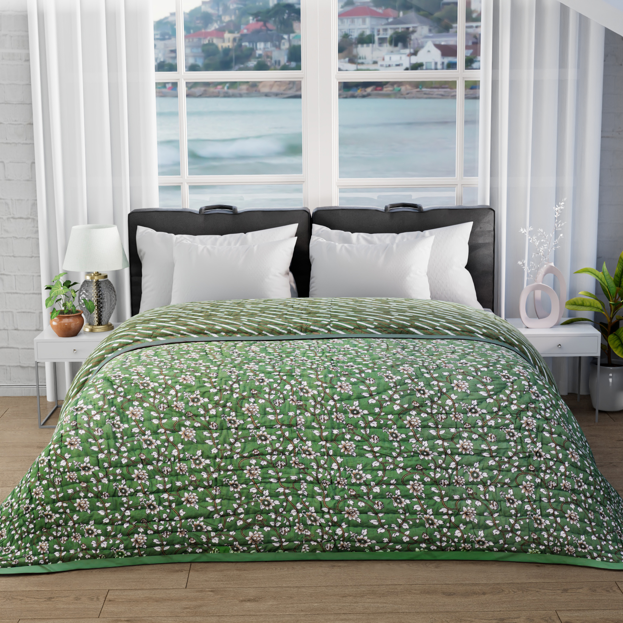 Bed with green floral bedding in a room with large windows showing a view of water and buildings.