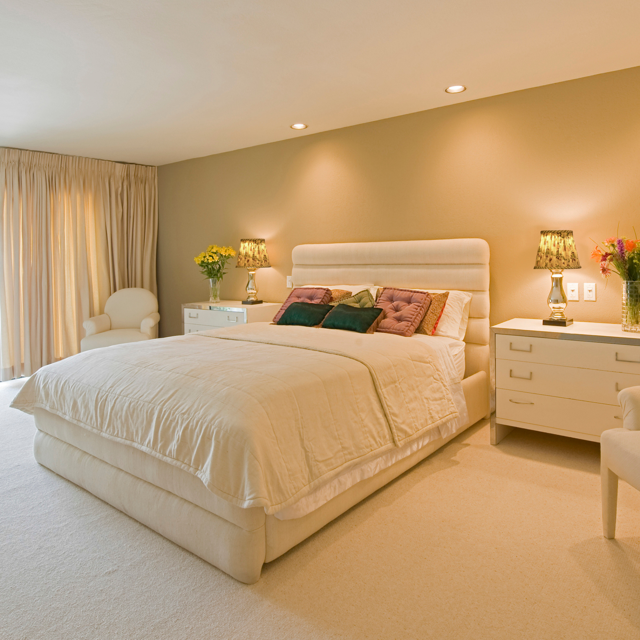 Neatly made bed in a bedroom with matching nightstands and lamps.