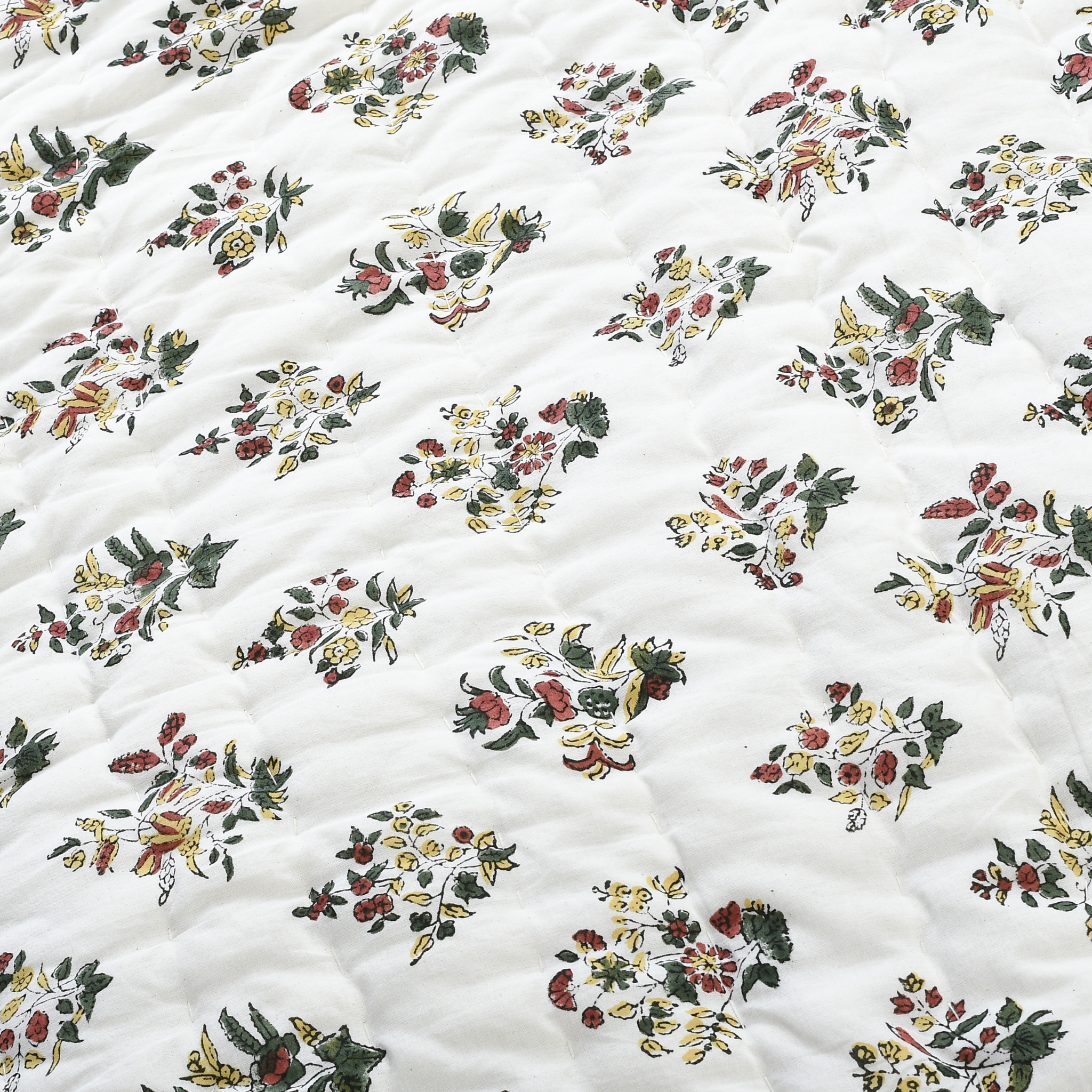 Floral patterned fabric with a quilted texture on a white background