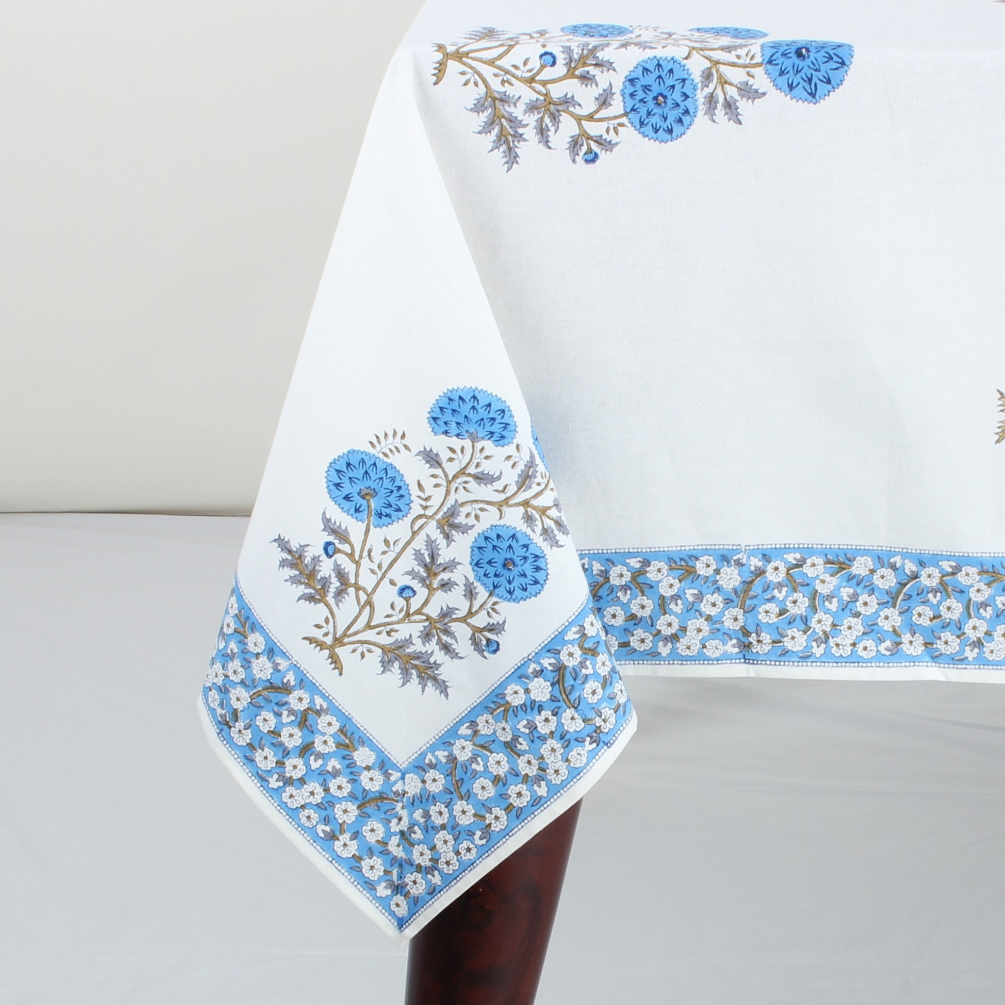 White tablecloth with blue floral embroidery on a white background