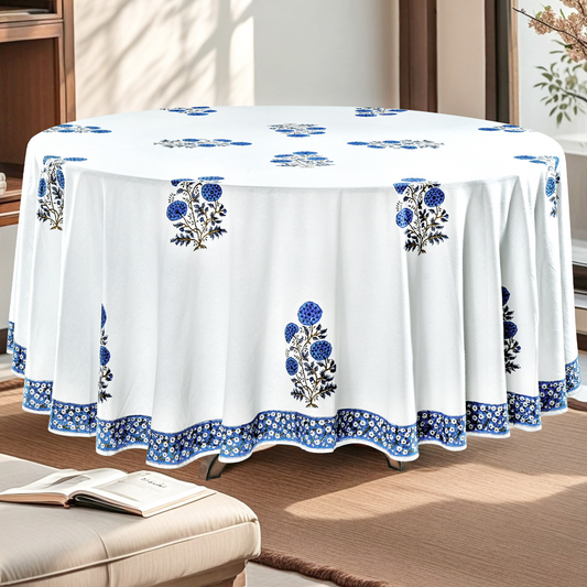 White tablecloth with blue floral patterns on a round table in a room.