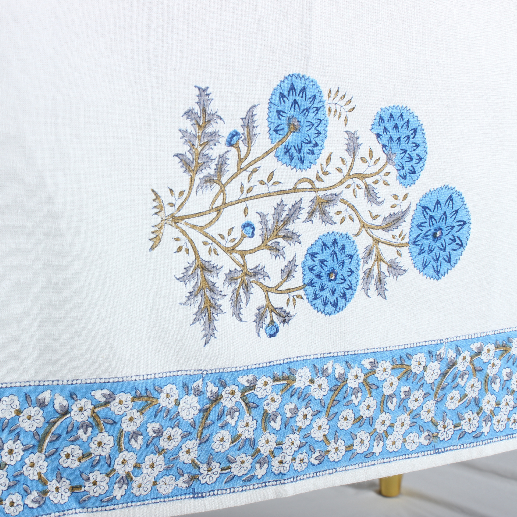 Embroidered fabric with blue floral design on a white background