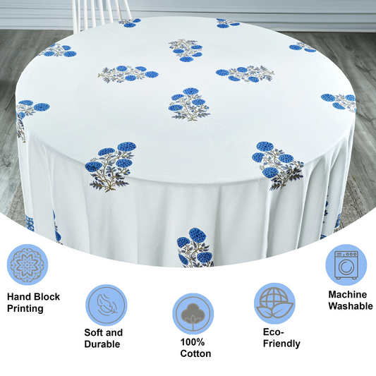 Round tablecloth with blue floral patterns on a wooden floor, featuring icons and text about material and care.
