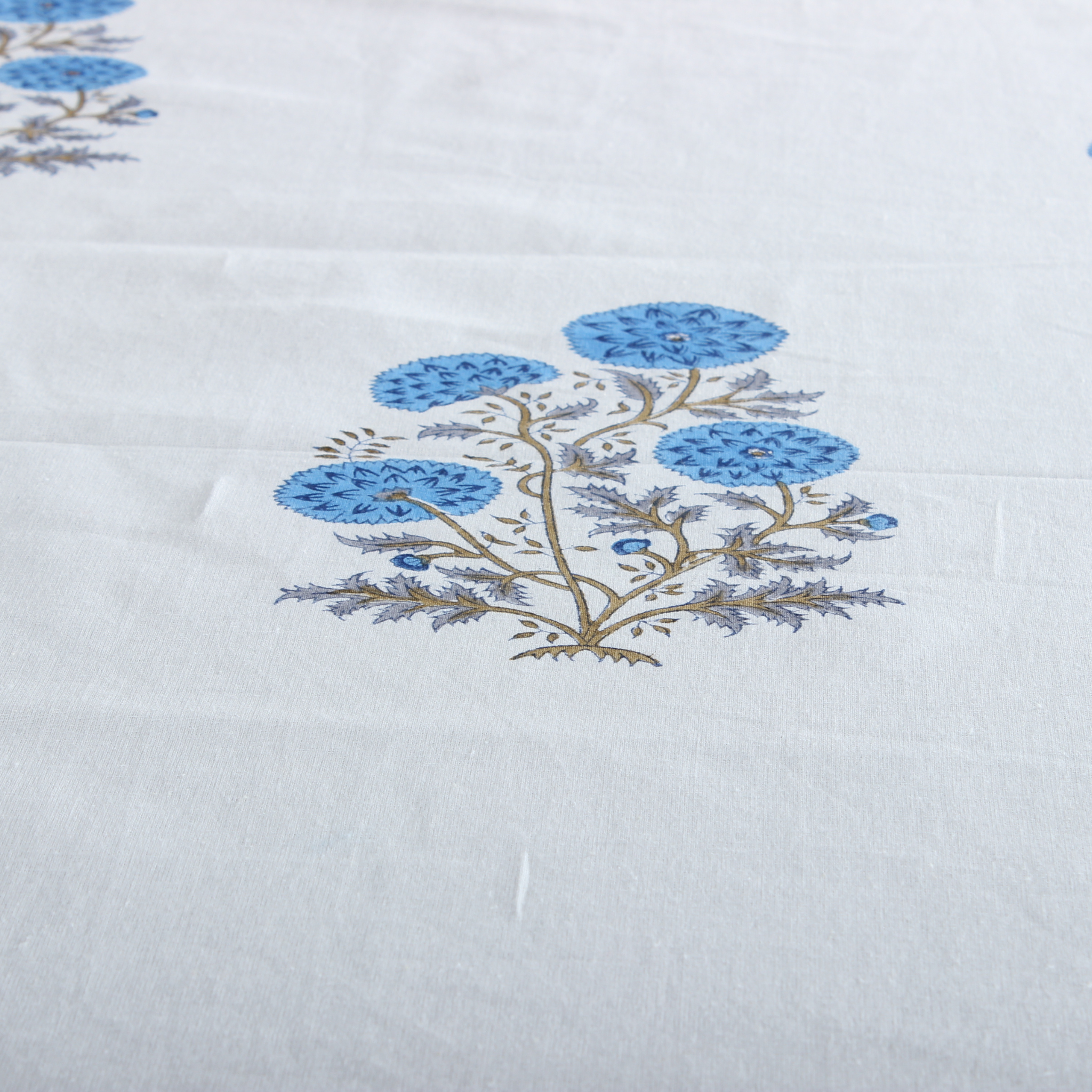 Floral pattern with blue flowers on a white fabric background