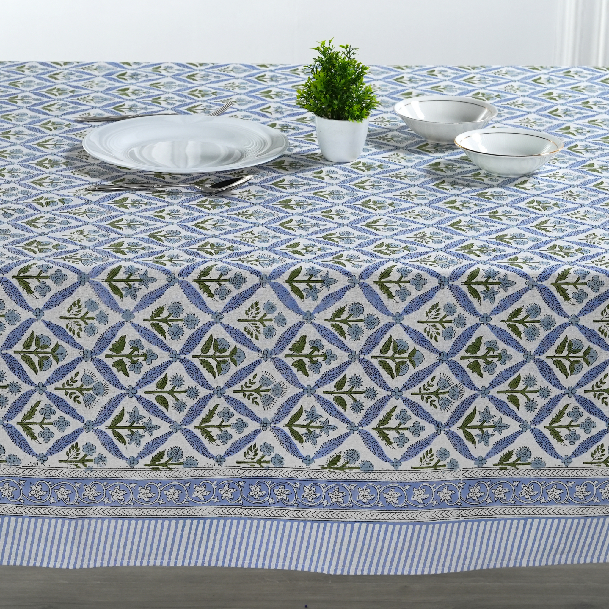 Tablecloth with blue and green geometric pattern on a table setting.