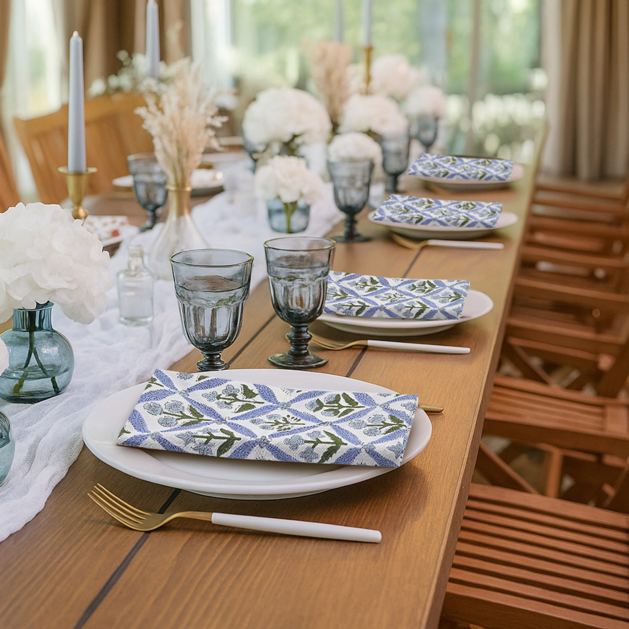 Elegant table setting with plates, glasses, and napkins on a wooden table.