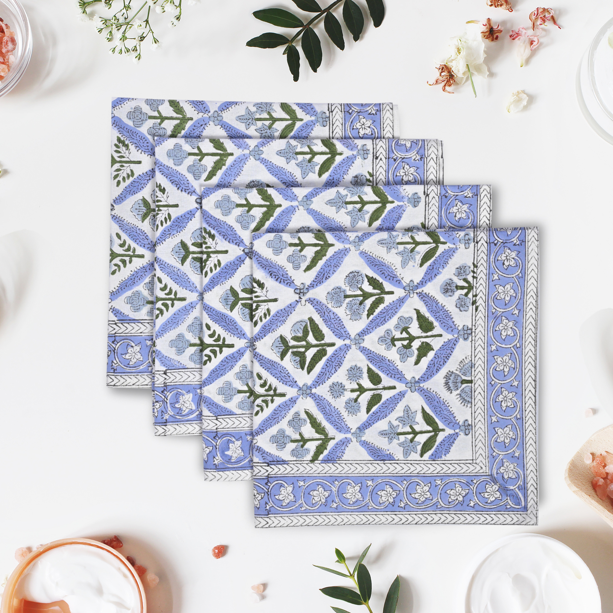 Set of three blue and white patterned placemats on a white surface with decorative elements.
