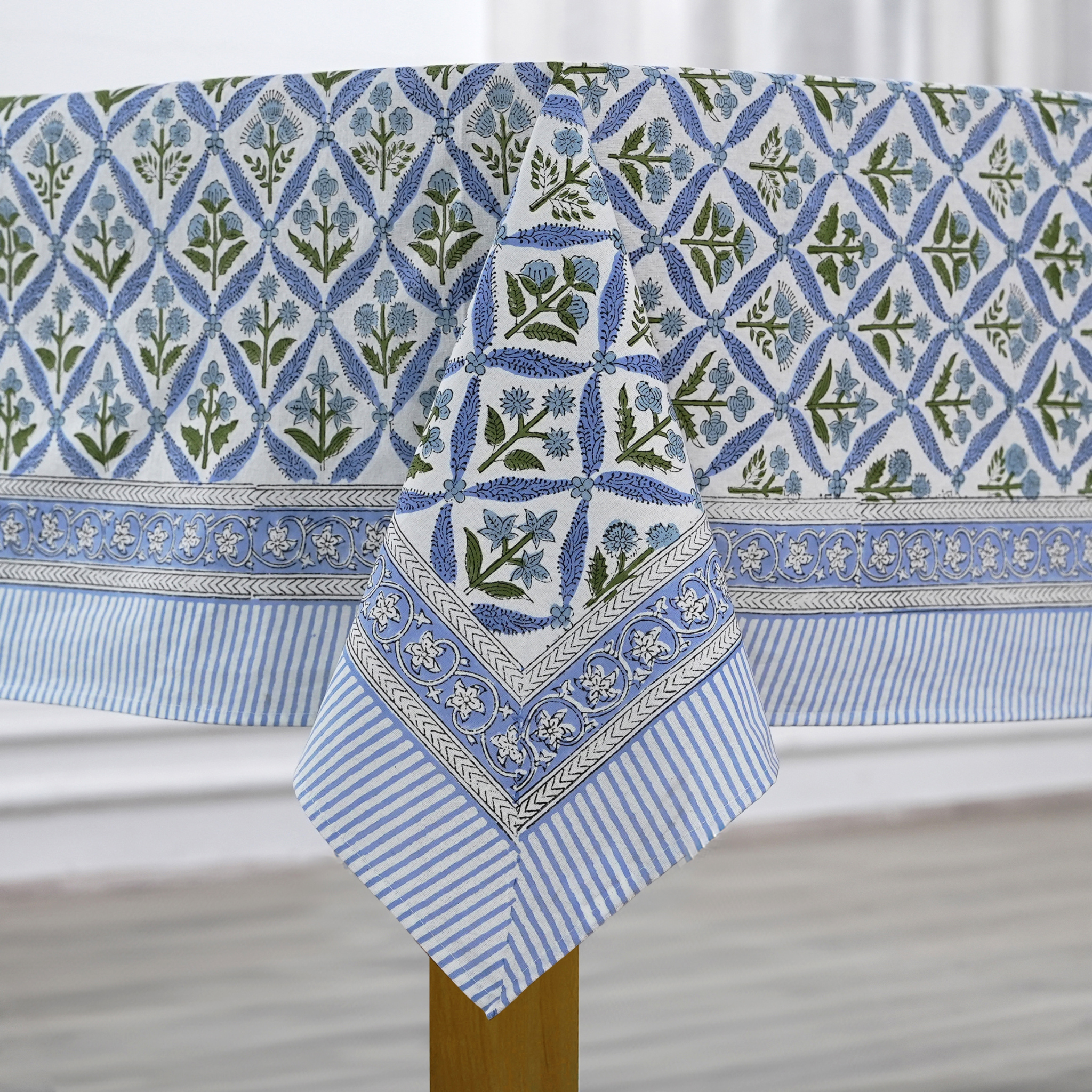 Blue and white patterned tablecloth with a geometric design on a wooden table.