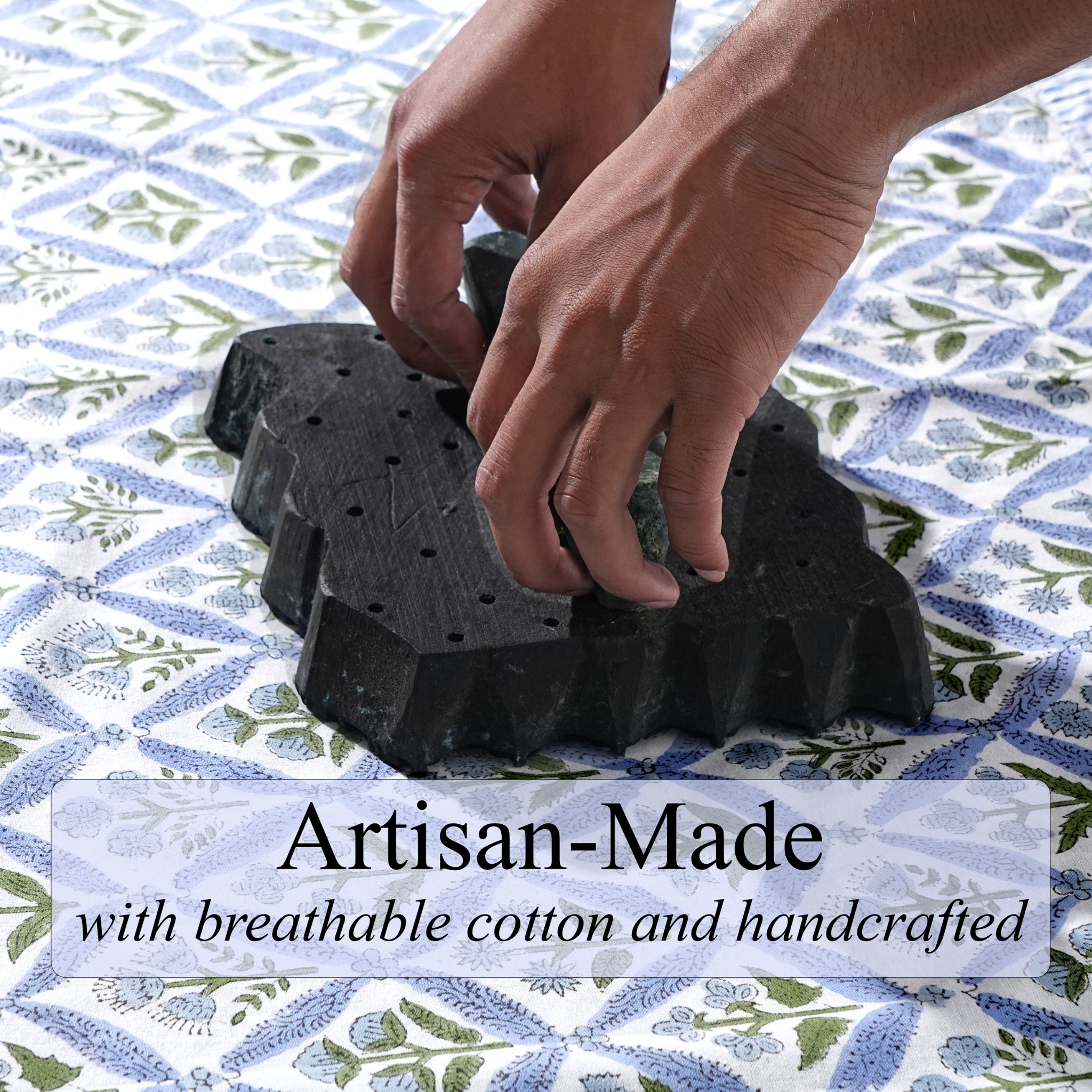Black rubber mat with hands on top, placed on a patterned fabric background, with text 'Artisan-Made with breathable cotton and handcrafted'.