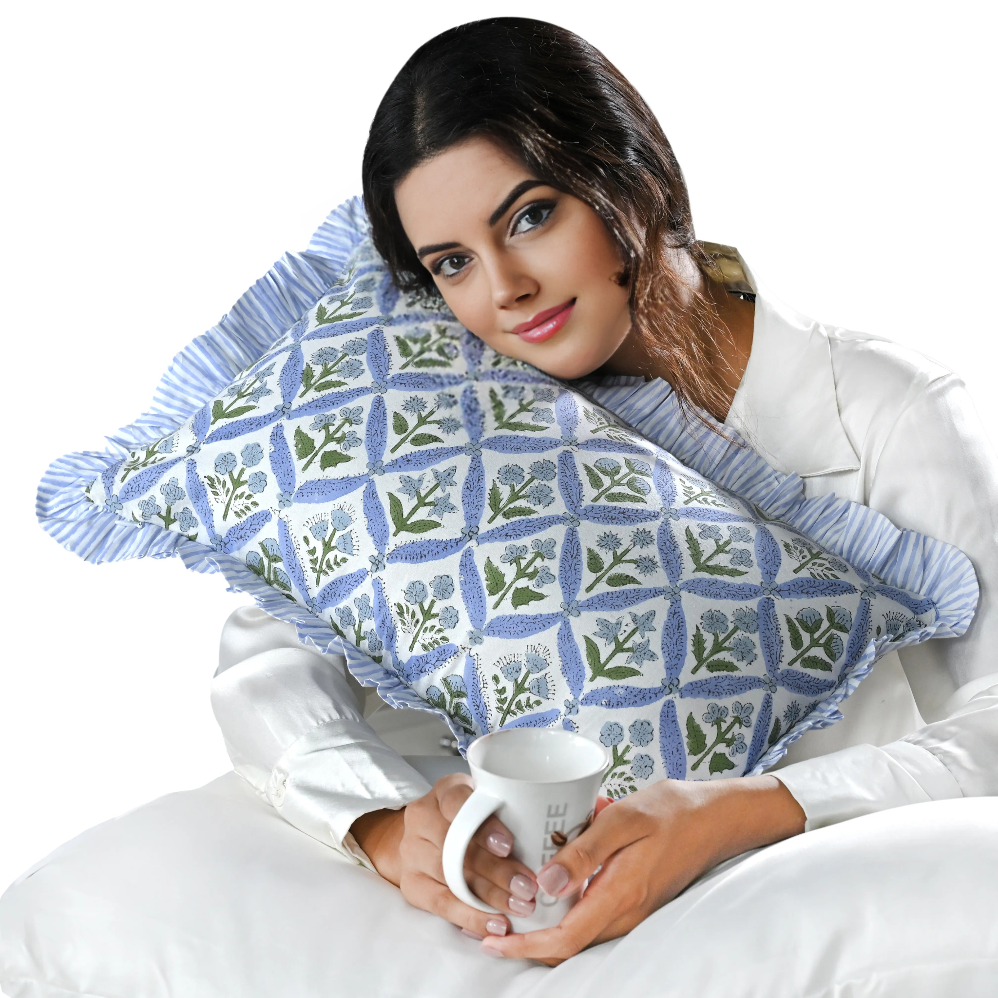Woman holding a patterned pillow and a mug on a white background