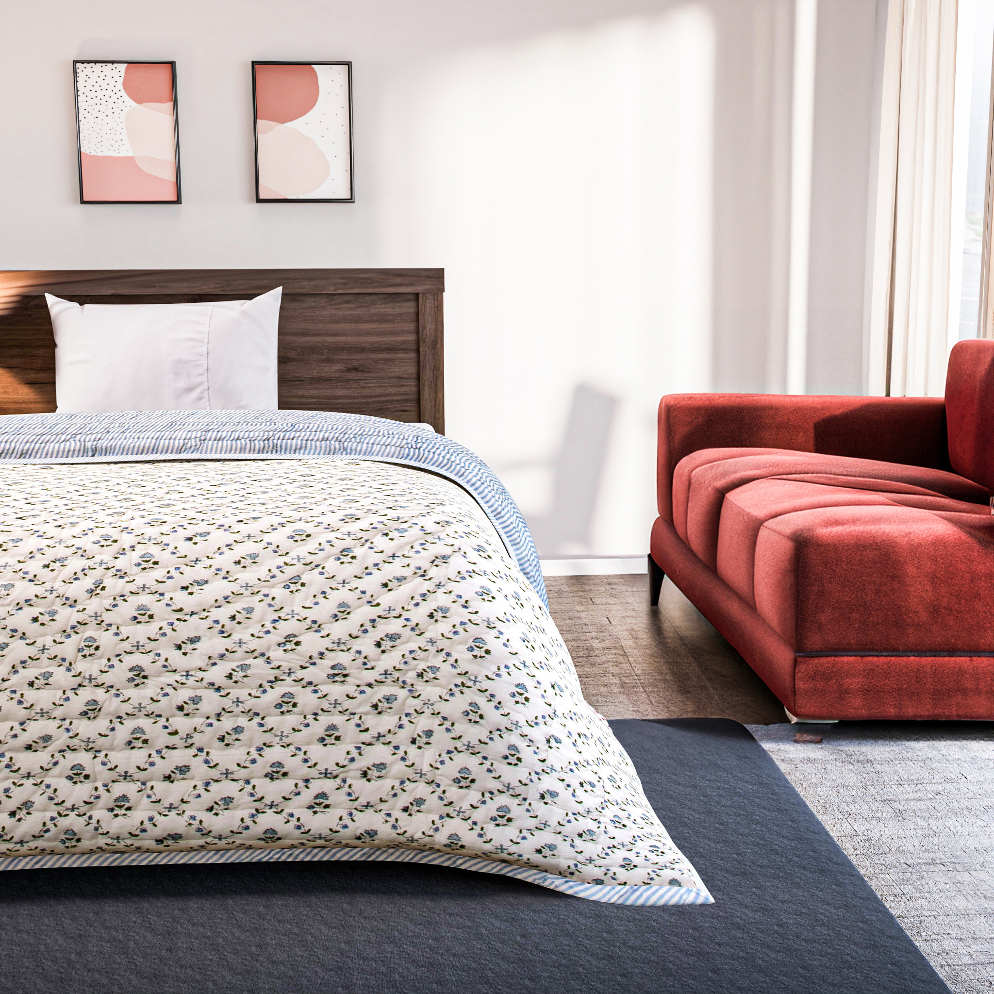 Bedroom with floral comforter on bed and red sofa against white wall