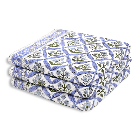 Stack of floral-patterned fabric sheets on a white background