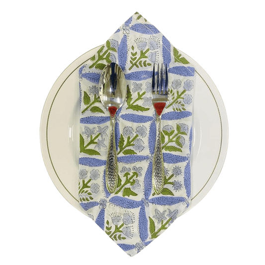 Napkin with floral pattern, fork, and spoon on a white plate