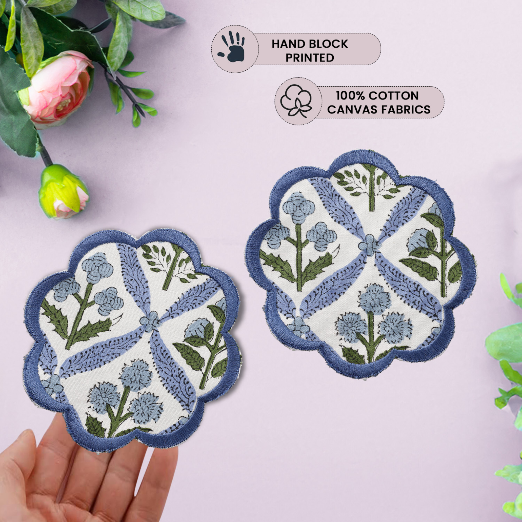 Decorative coasters with floral patterns held by a hand on a light pink background.