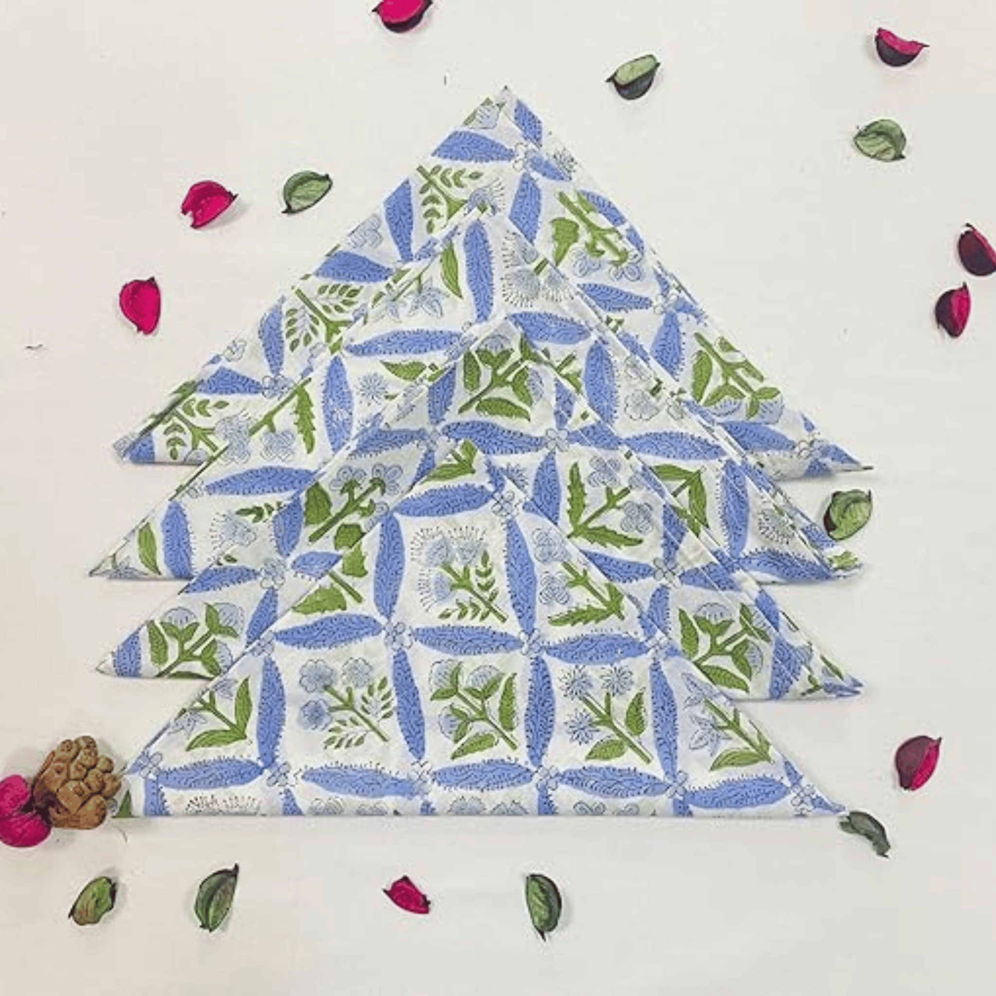 Stack of folded fabric with a floral pattern on a white background with decorative elements.