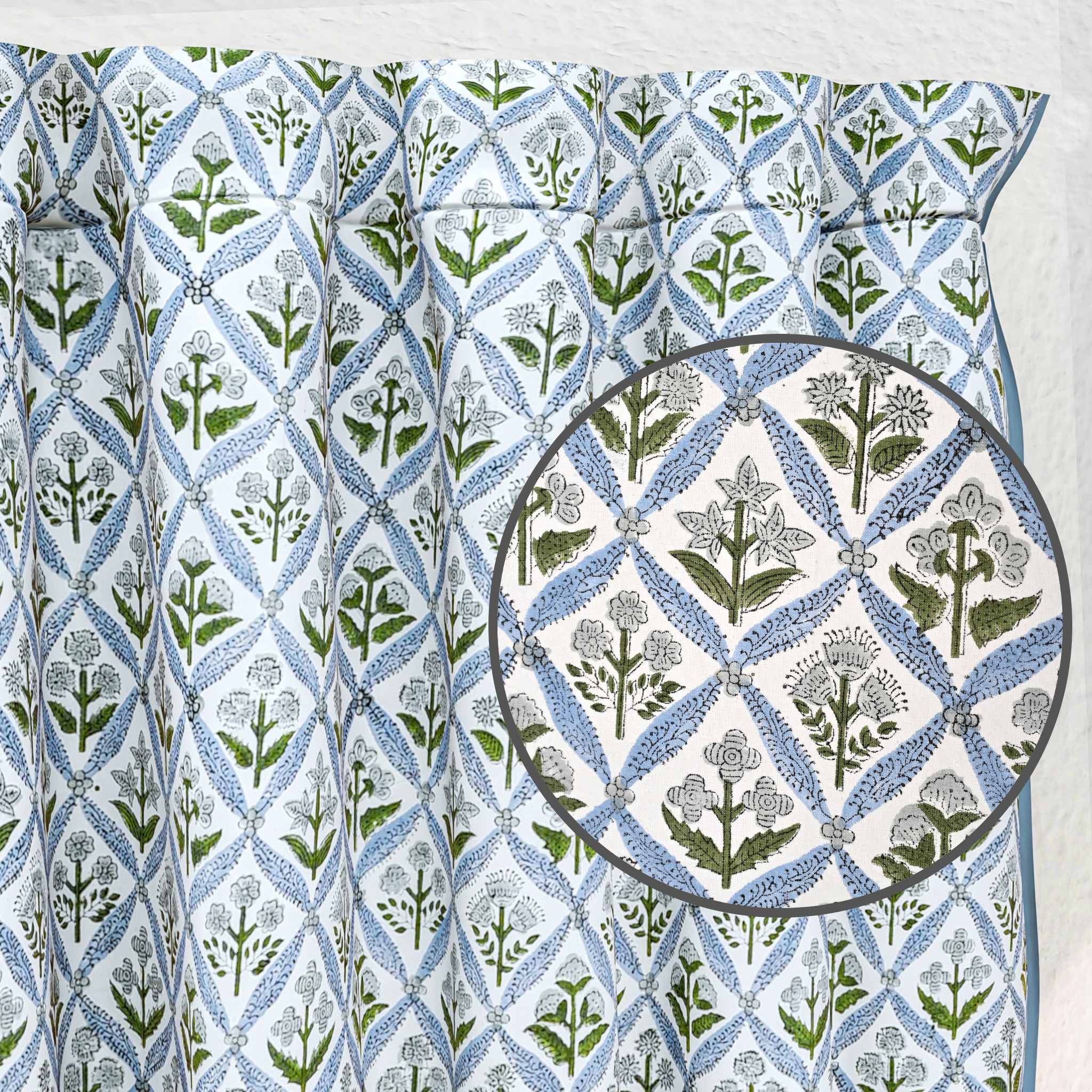 Fabric with a geometric pattern featuring green and blue shapes on a white background