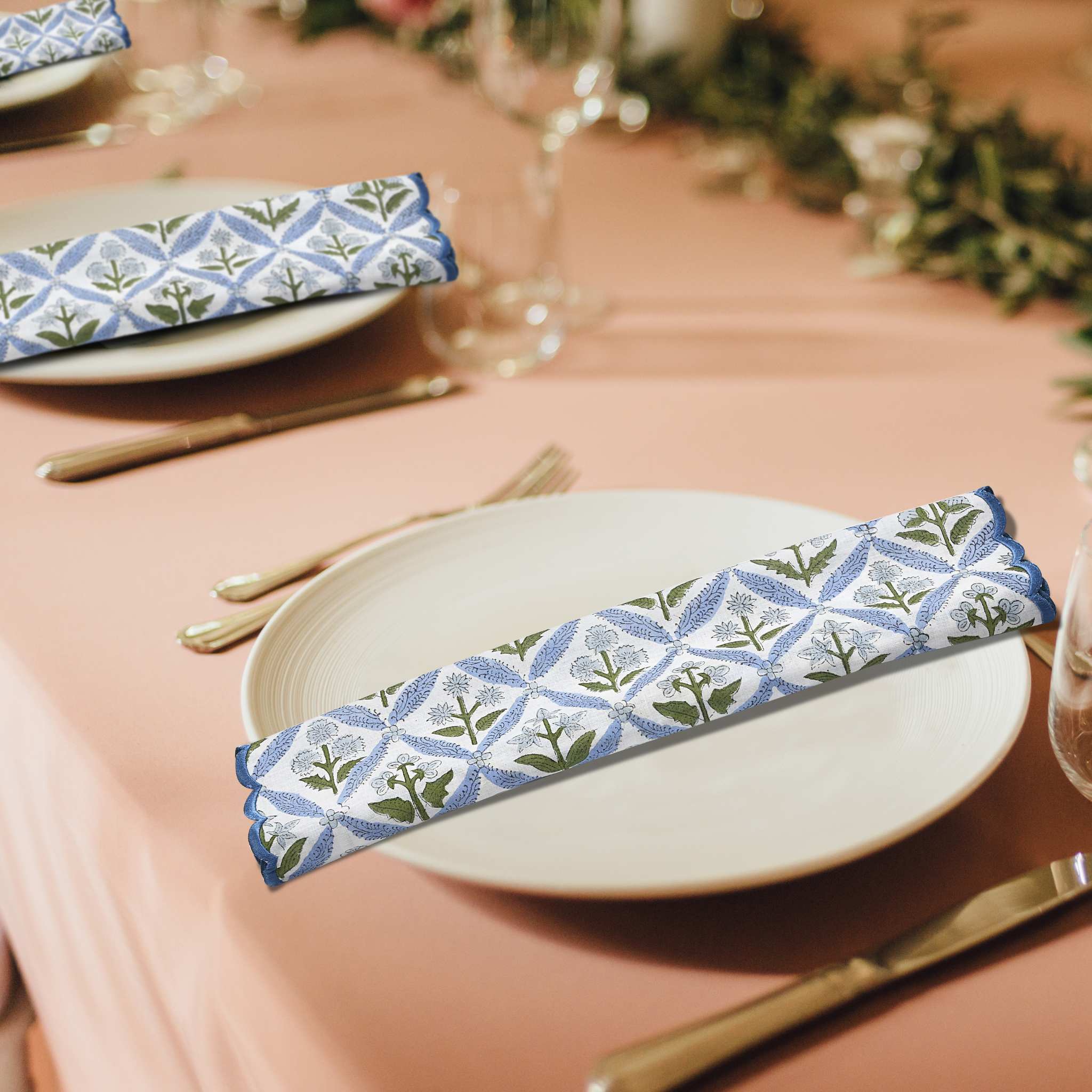 Table setting with floral-patterned napkins on plates, cutlery, and glasses.