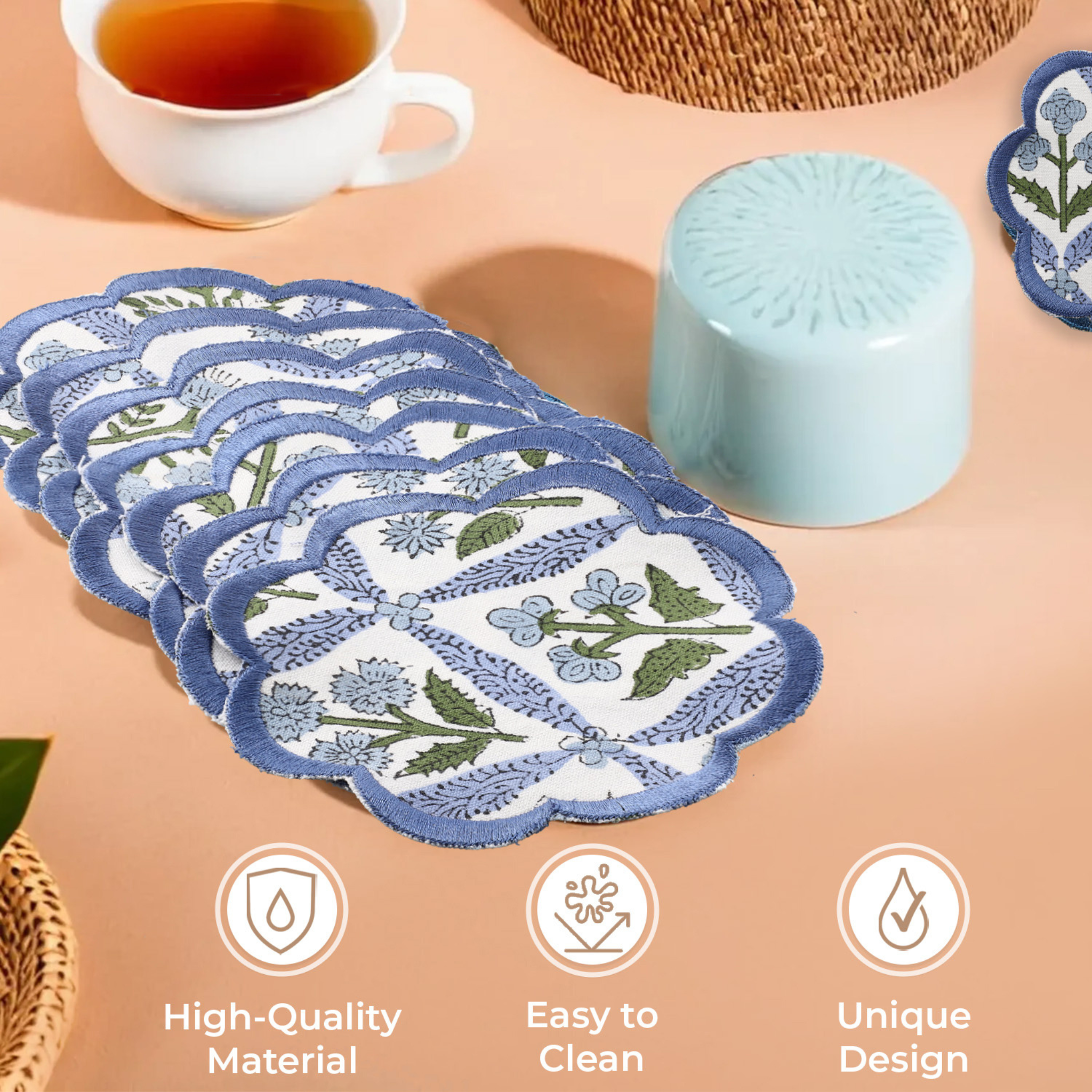 Set of blue floral coasters on a table with tea and a candle.