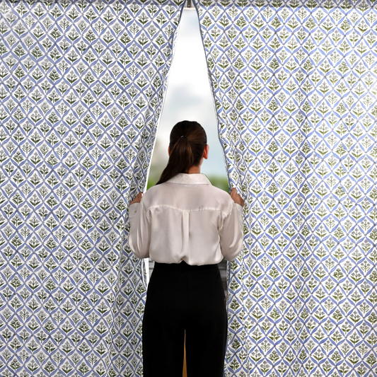 Person standing in front of a patterned wall with a window showing a scenic view.