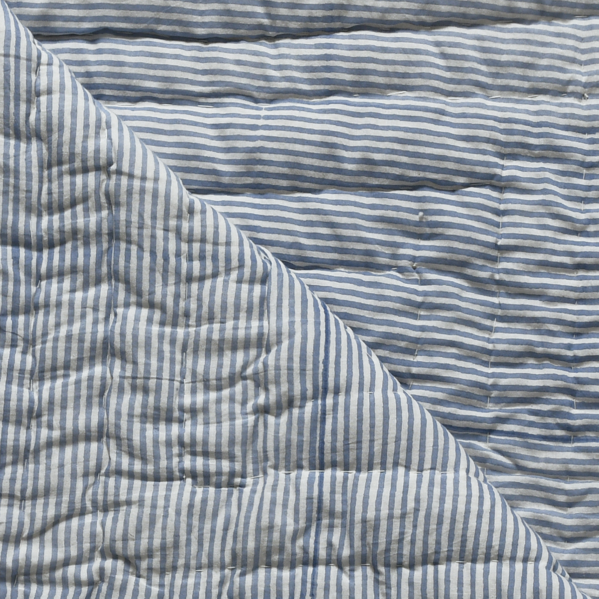 Close-up of a blue and white striped quilted fabric