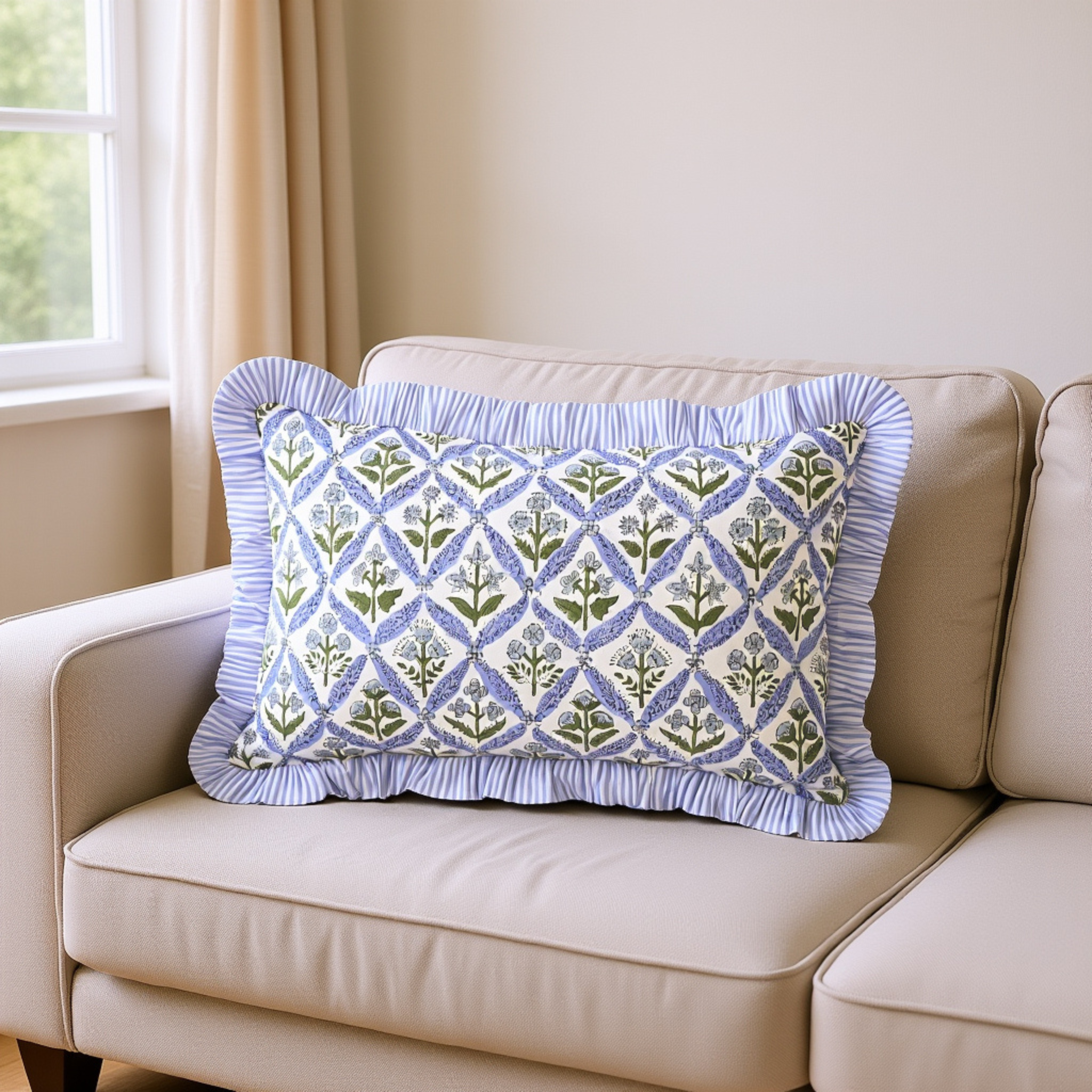 Decorative pillow with blue and green pattern on a beige sofa near a window.