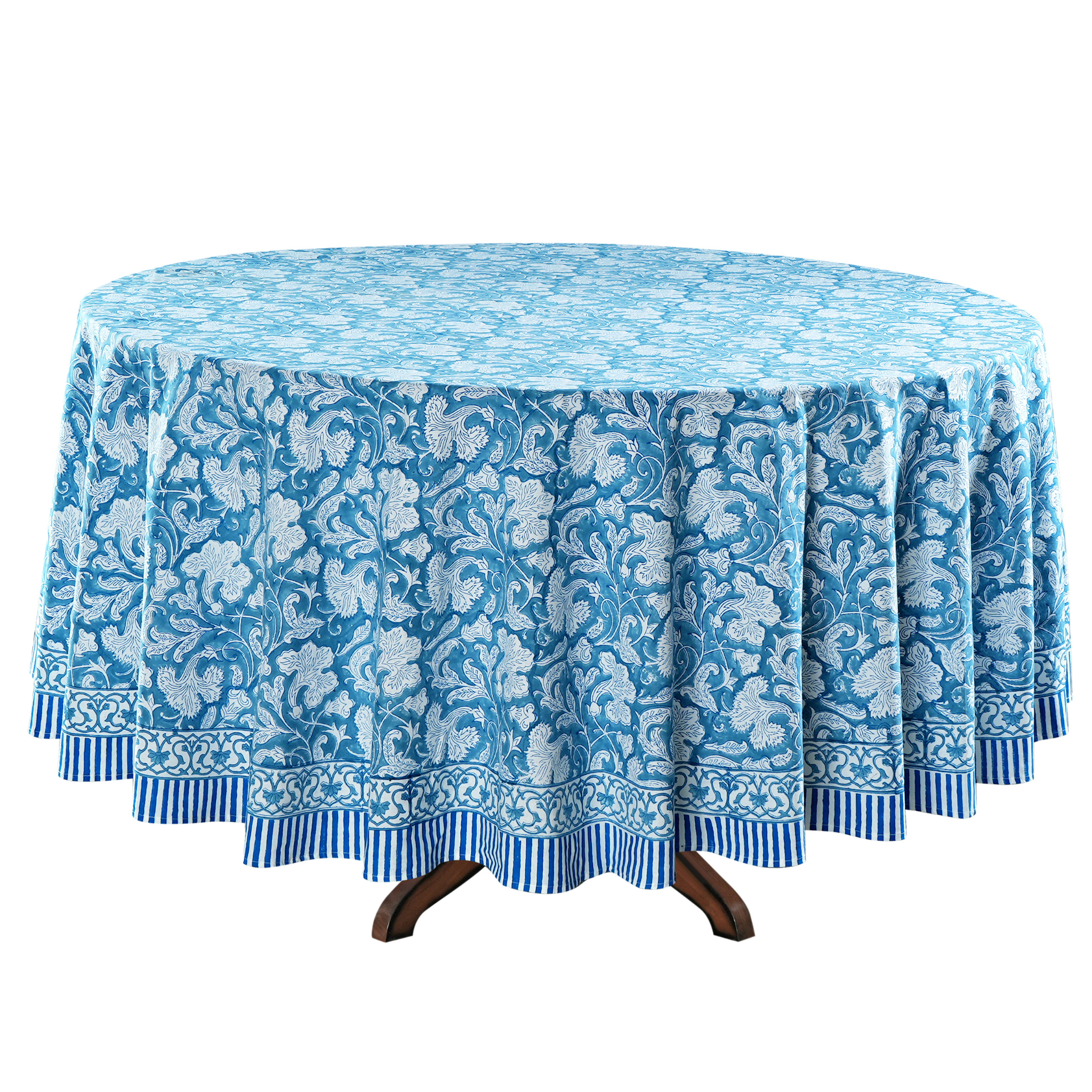 Round table with a blue floral patterned tablecloth on a white background