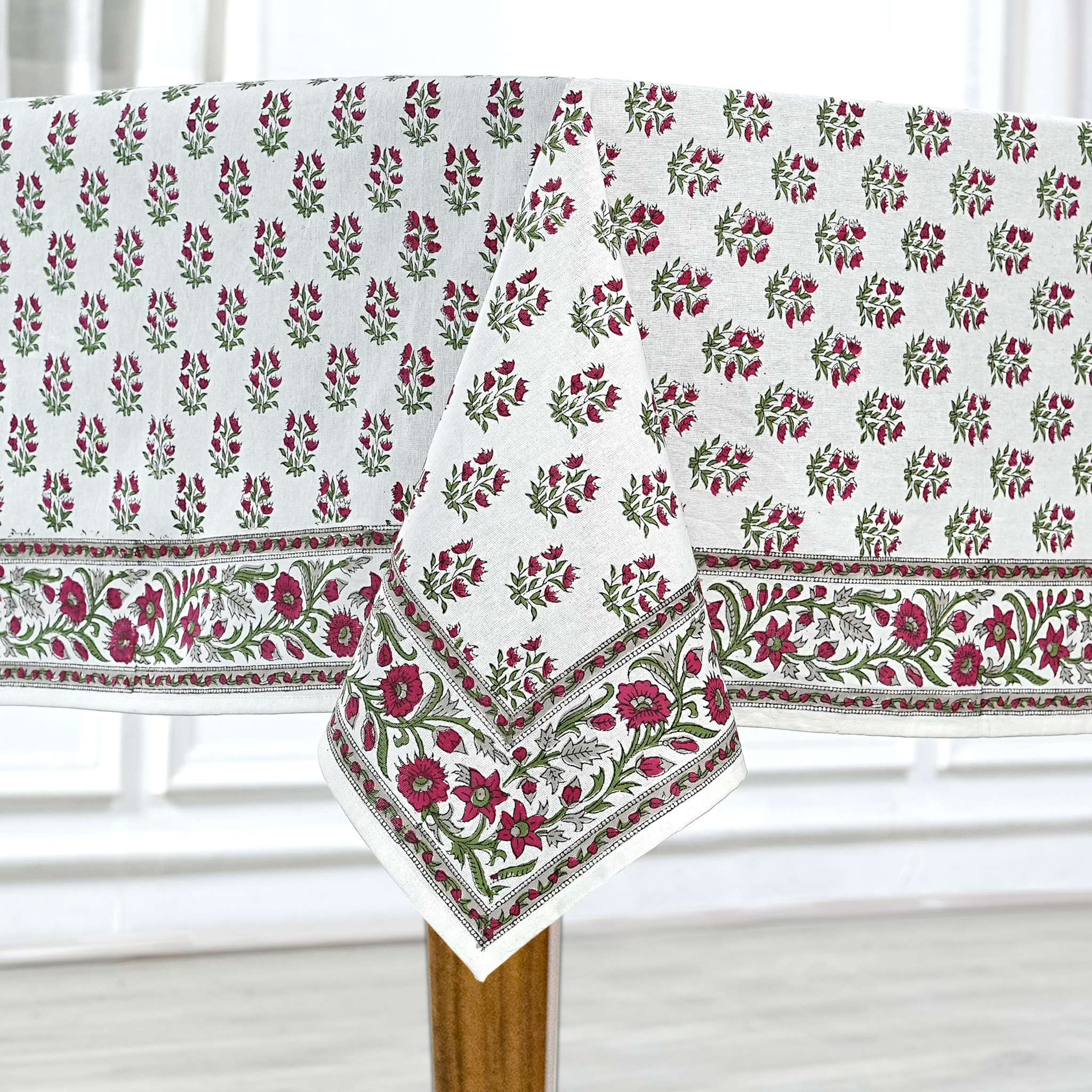 Floral patterned tablecloth on a wooden table with a white background